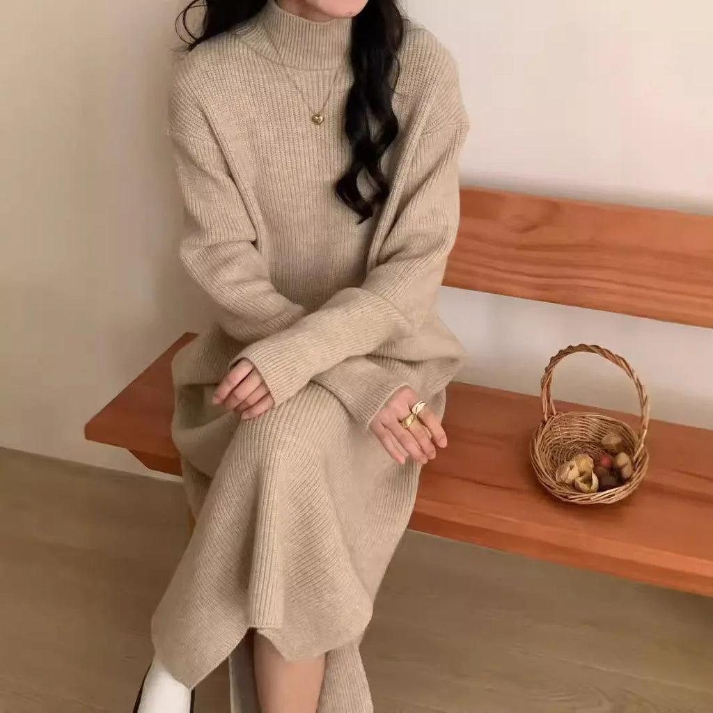 A woman wearing a beige turtleneck knitted dress with long sleeves and a high waist.