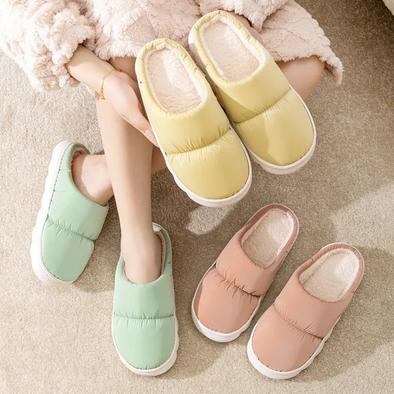 A pair of thick-soled indoor slippers with an artificial leather upper and soft plush lining, shown in a choice of colours.