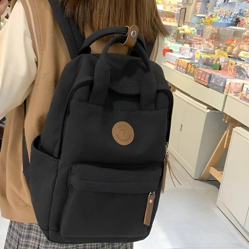Black retro-style Oxford cloth backpack with curved shoulder straps.