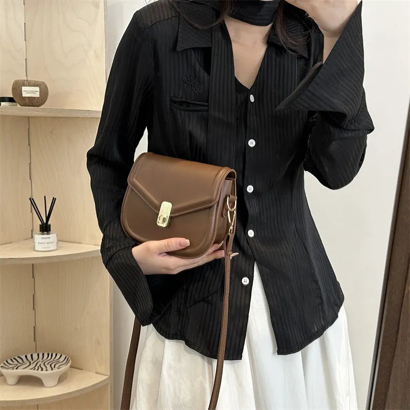 Soft PU leather clamshell shoulder messenger bag in horizontal square shape on adjustable strap.