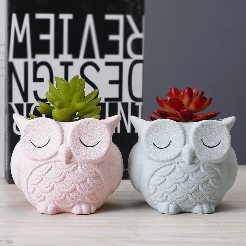 Handmade frosted ceramic owl succulent pot in pastel colour on a wooden surface.