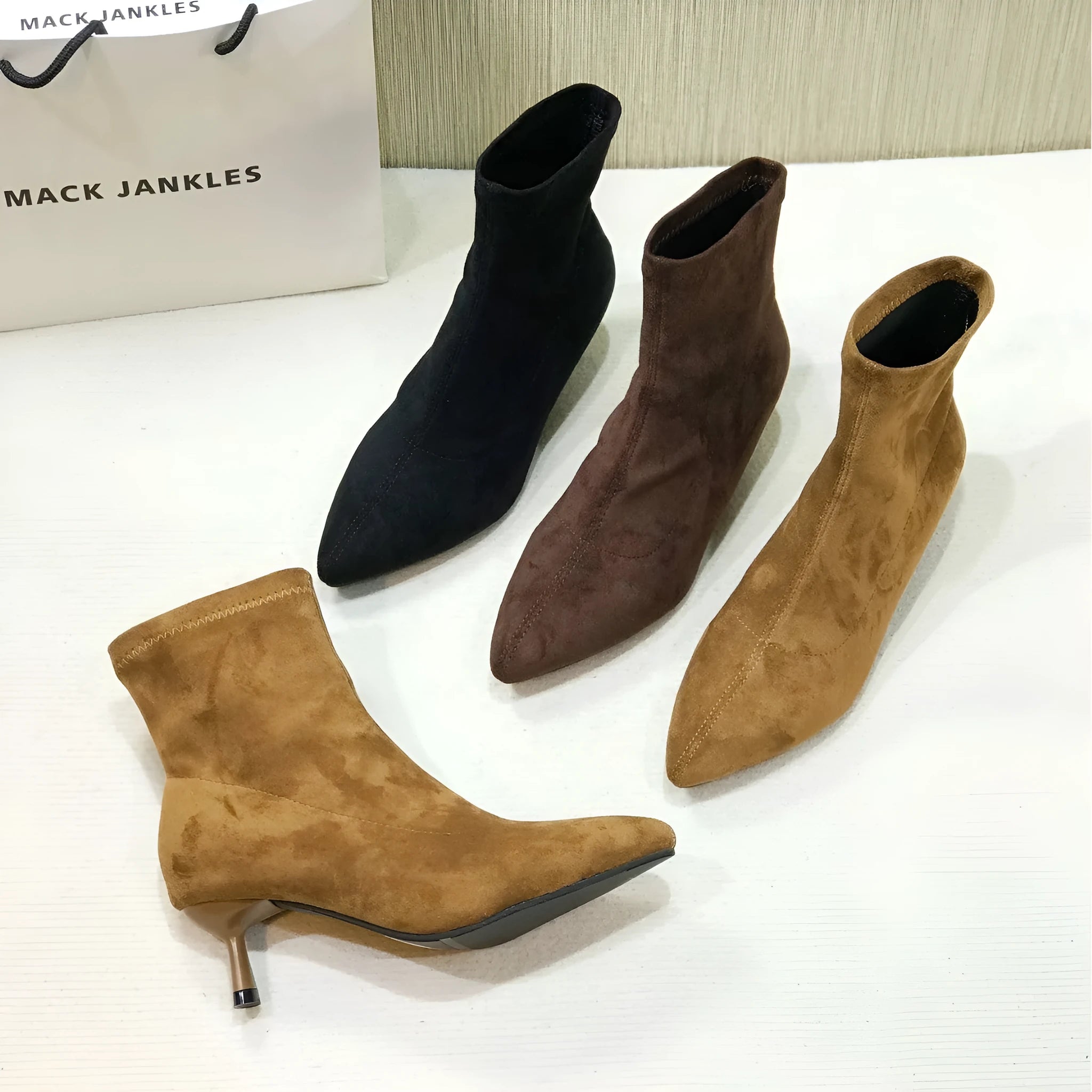 Women's black pointed toe ankle boots with a stiletto heel on a rubber sole.