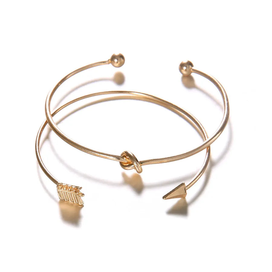 Gold-coloured women's vintage cuff bracelet with arrow and knot design in electroplated alloy