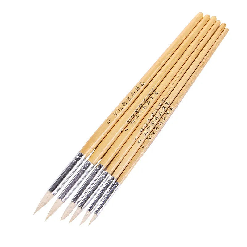 Six wooden crochet hook pen brushes with pointed handles arranged together.