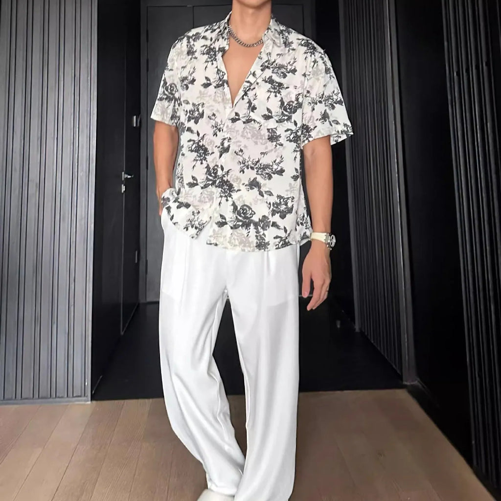Loose black floral print short sleeve casual shirt on a hanger.