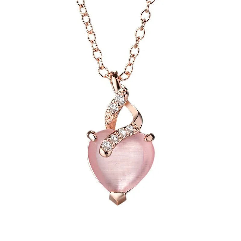 Rose gold women's necklace with heart-shaped pink crystal pendant on cross chain