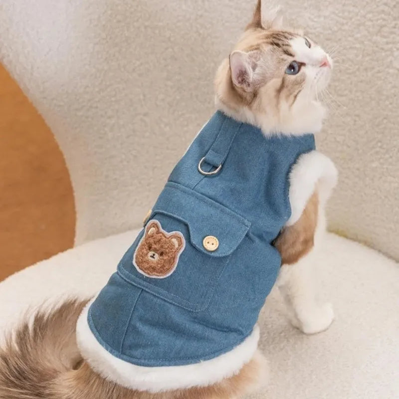 Denim blue pet vest with white wool lining, bear print, wooden buttons, and metal D-ring.