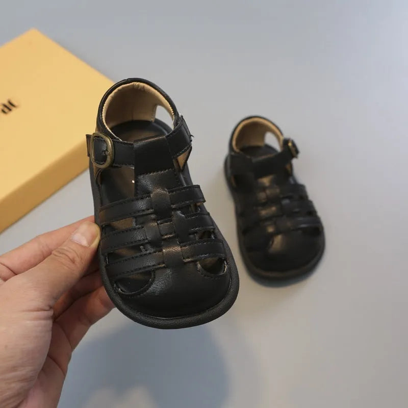 Girls' closed toe PU leather woven hollowed Roman sandals with Velcro strap, beige colour, on toddler feet