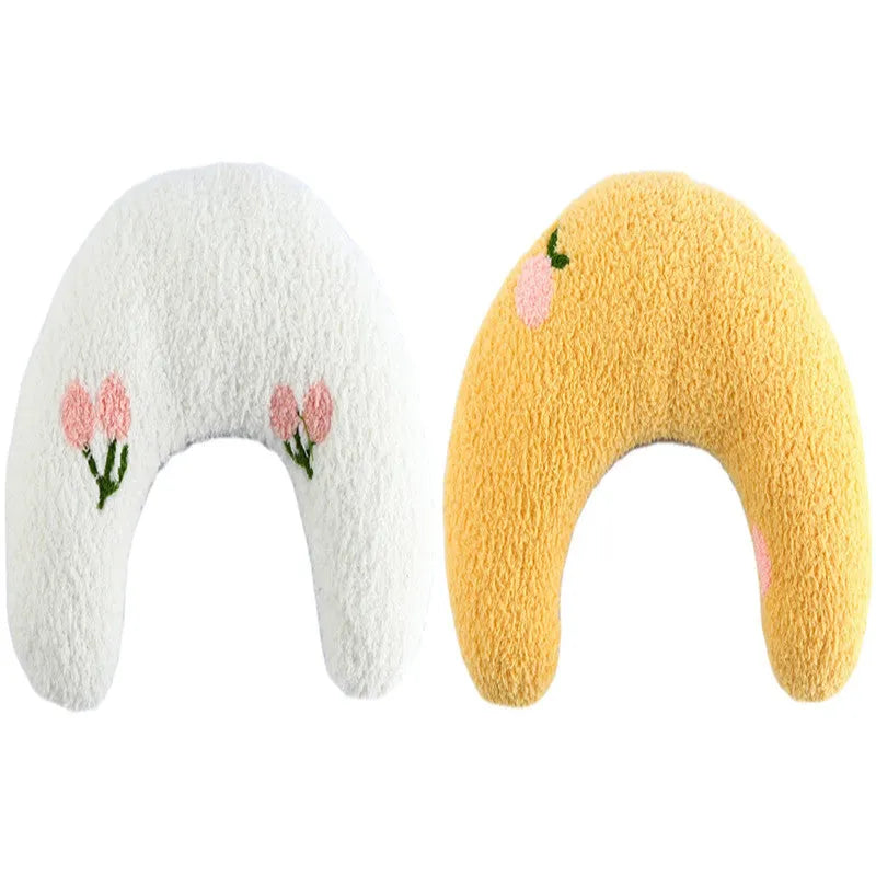 White U-shaped plush pet pillow for a cat, showing its donut shape and quilted texture.