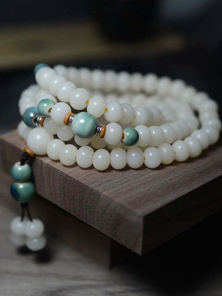 White Jade Bodhi Root Oblate Bead Bracelet with 108 flat round beads on a wrist.