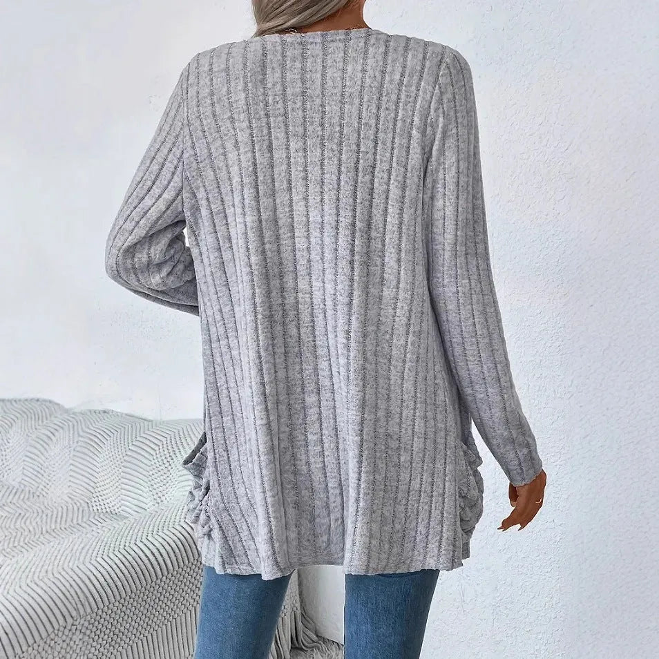 A solid colour long sleeve cardigan with pockets, shown in loose fit on a model.