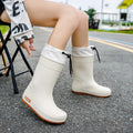 Women's solid colour PVC rain boots with non-slip soles in apricot, black, brown, and pink options