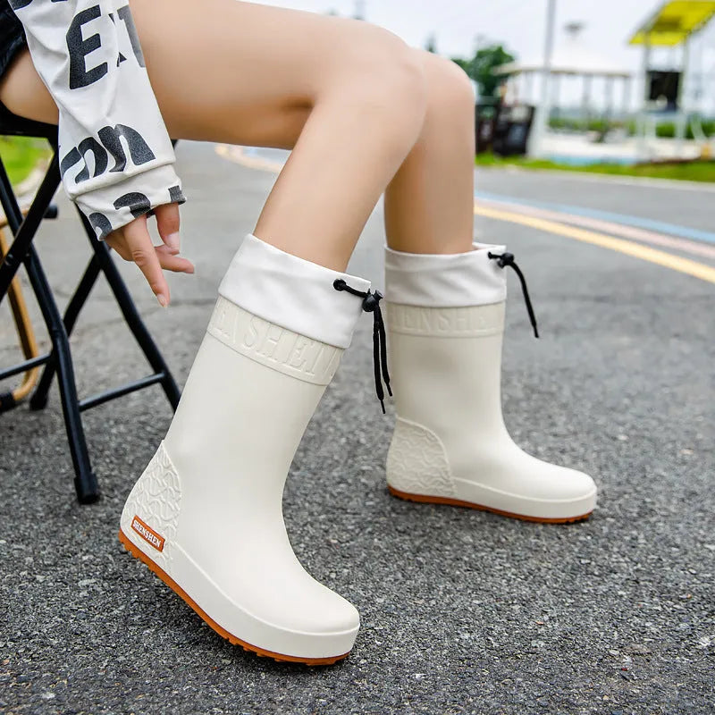 Women's solid colour PVC rain boots with non-slip soles in apricot, black, brown, and pink options
