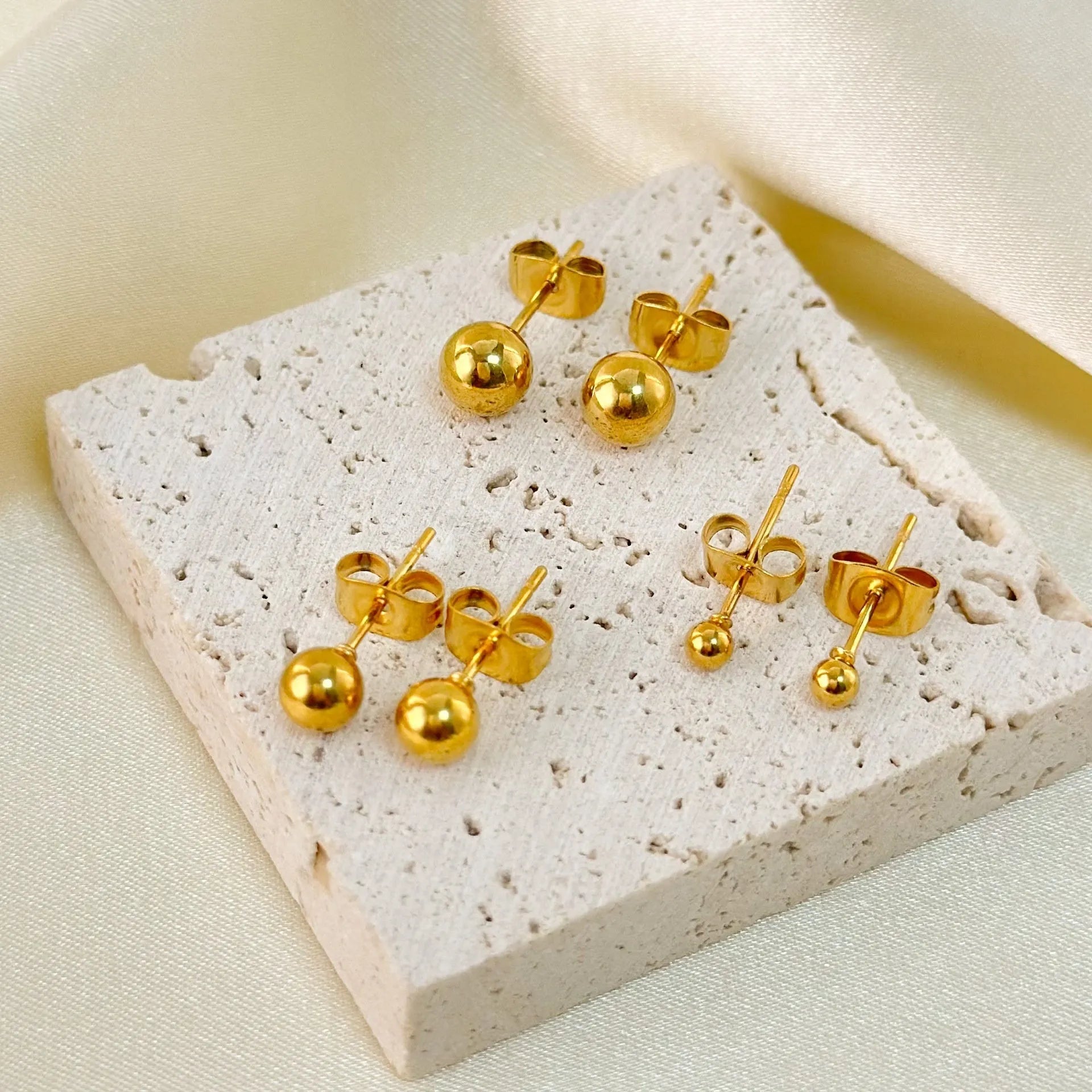 Stainless steel ball stud earrings with gold or silver electroplating in minimalist geometric design.