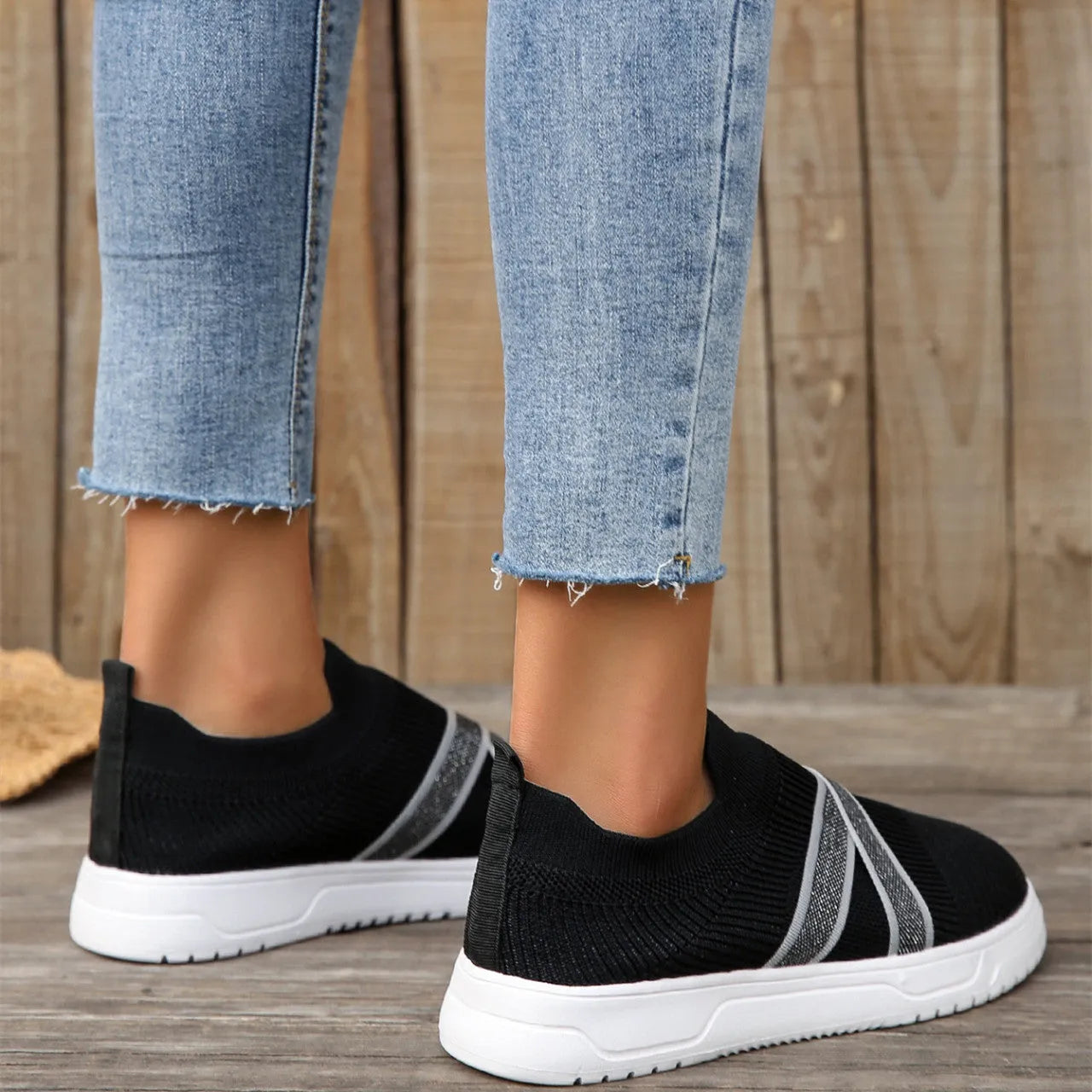 Black women's low-top casual shoes with Flyknit mesh fabric and a flat rubber sole.