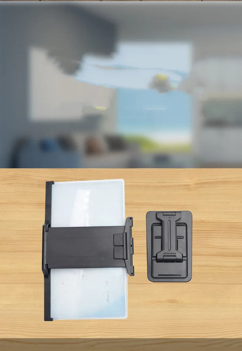 Black folding mobile phone screen amplifier with detachable holder next to an iPhone.