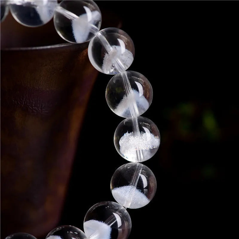 Women's adjustable white crystal ghost pyramid bracelet with Ruyi charm on wrist.