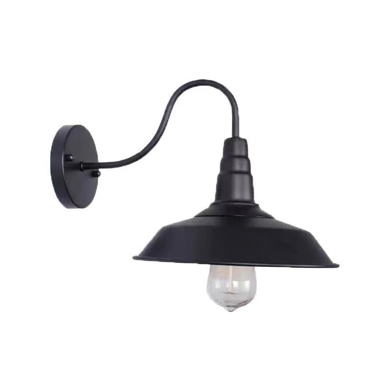 Retro style outdoor wall lamp in a copper finish with an oblique angle mount on a garden wall.