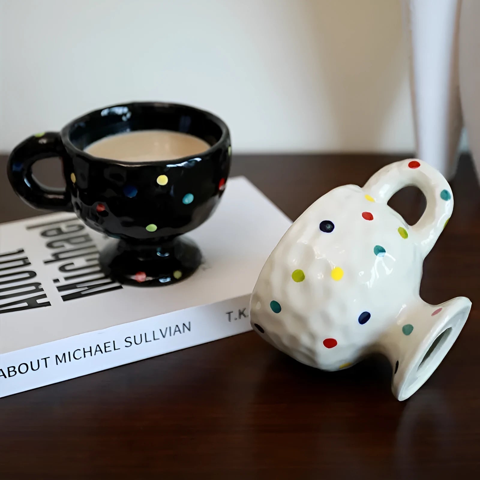 Handmade irregularly shaped ceramic mug in a solid colour, shown on a table.