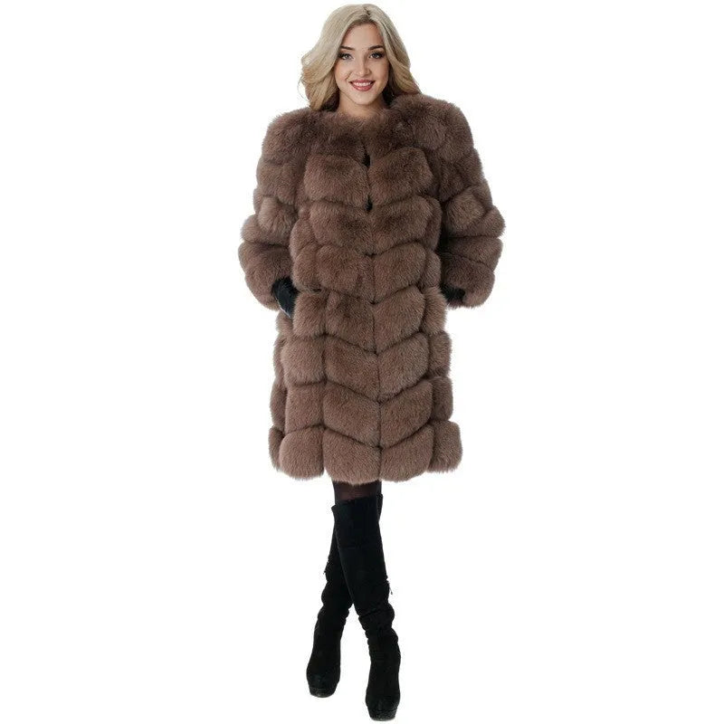 A woman wearing a long black artificial fur coat with regular sleeves.