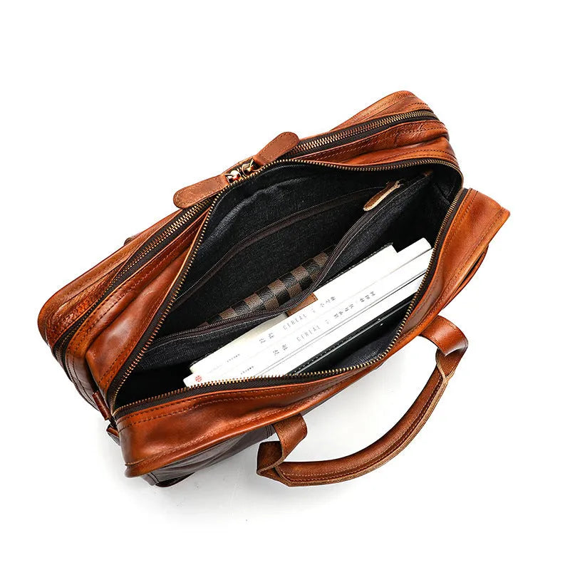 Large vintage leather men's briefcase showing internal laptop, document, camera, and phone compartments