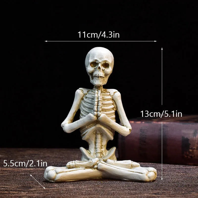 A detailed resin desktop ornament of a yoga-pose skeleton skull in black and white colour options.