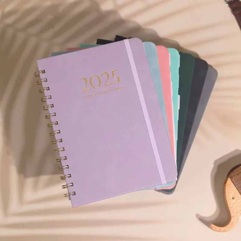 A5 leather notebook with metal coil binding in various colours including black, blue, and green.