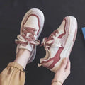 Women's pink and beige low-top sneakers with a rubber sole for height increase.