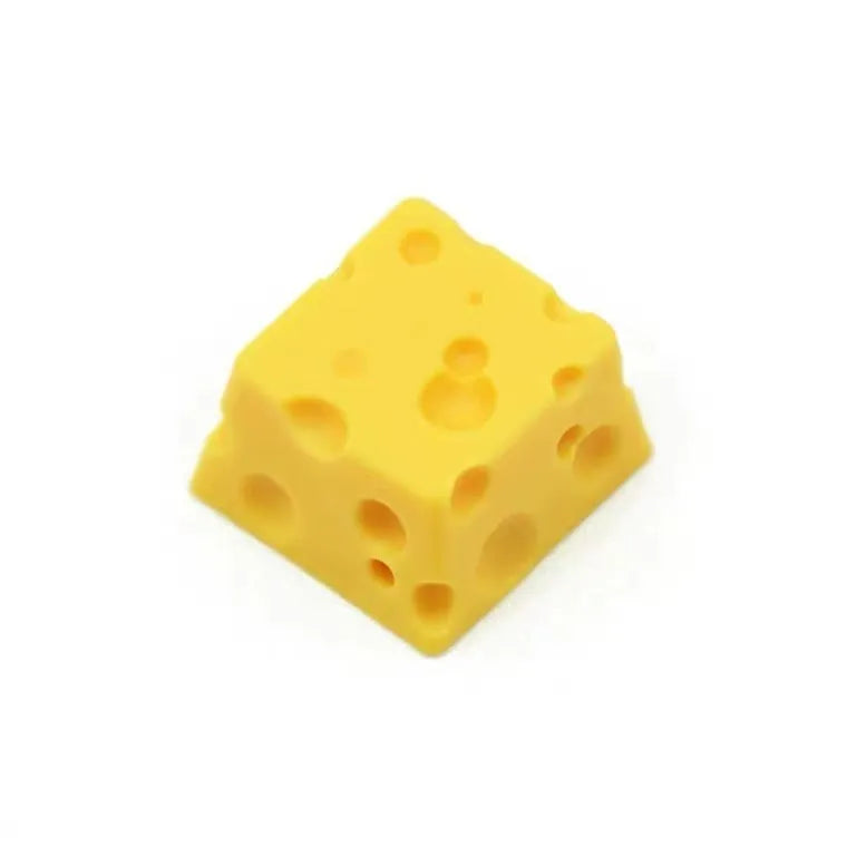 Close-up of a yellow resin cheese-shaped keycap for a mechanical keyboard.