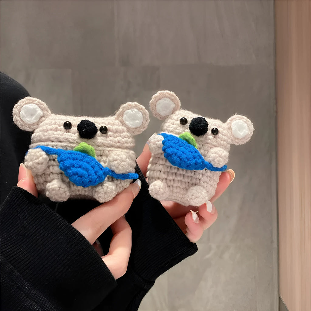 Hand-knitted grey koala bear backpack case for Apple AirPods on a wooden table.