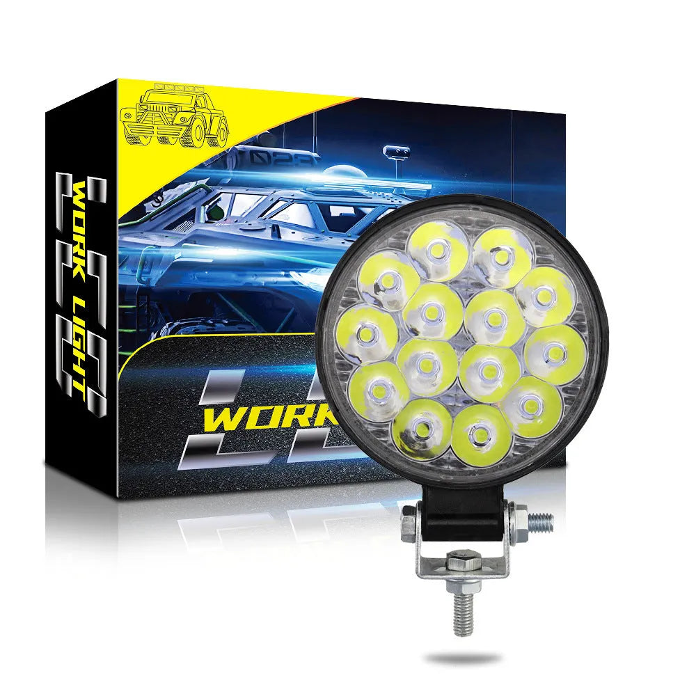 Compact round white LED work light with aluminium housing for car, truck, and off-road use.