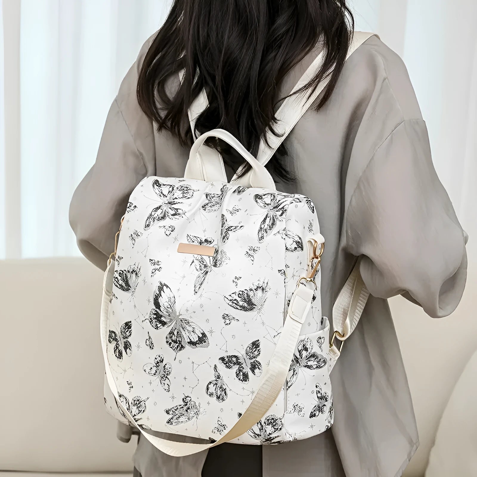 Butterfly print PU leather backpack in purple shown from the side, featuring sewing line details and shoulder straps.