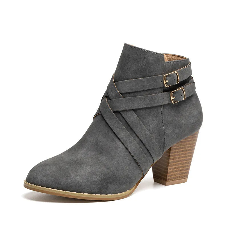 Plus size black short ankle boot with a 7cm heel, side zip, and buckle detail on a grey background.