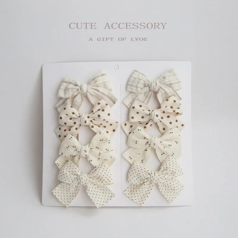 Children's cloth dovetail bow hairclip set showing eight colour pattern options