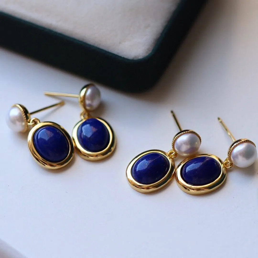 A pair of simple 925 silver stud earrings with a blue lapis lazuli pearl and auspicious patterns.
