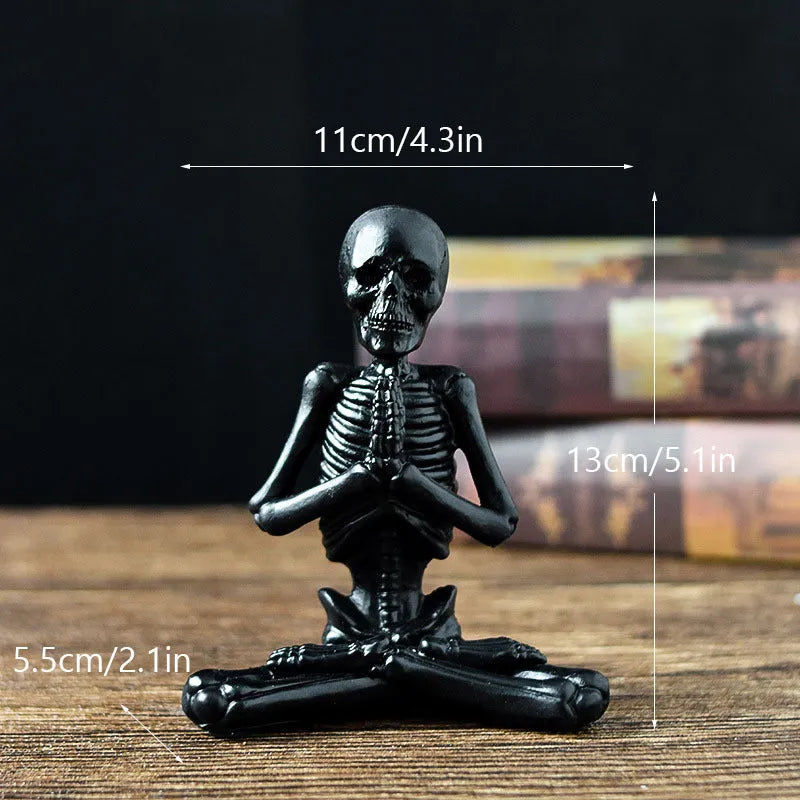 A detailed resin desktop ornament of a yoga-pose skeleton skull in black and white colour options.