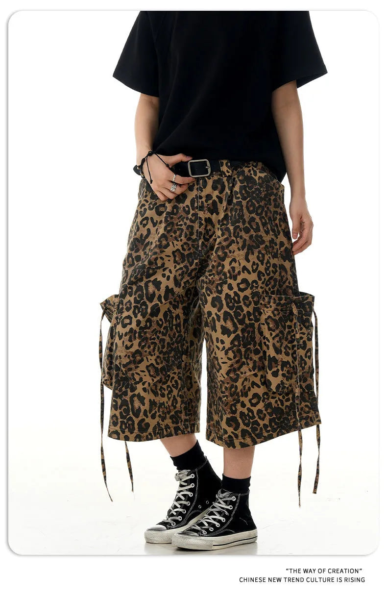 A pair of loose-fitting, high-waisted, straight-leg cropped pants in a leopard print pattern.