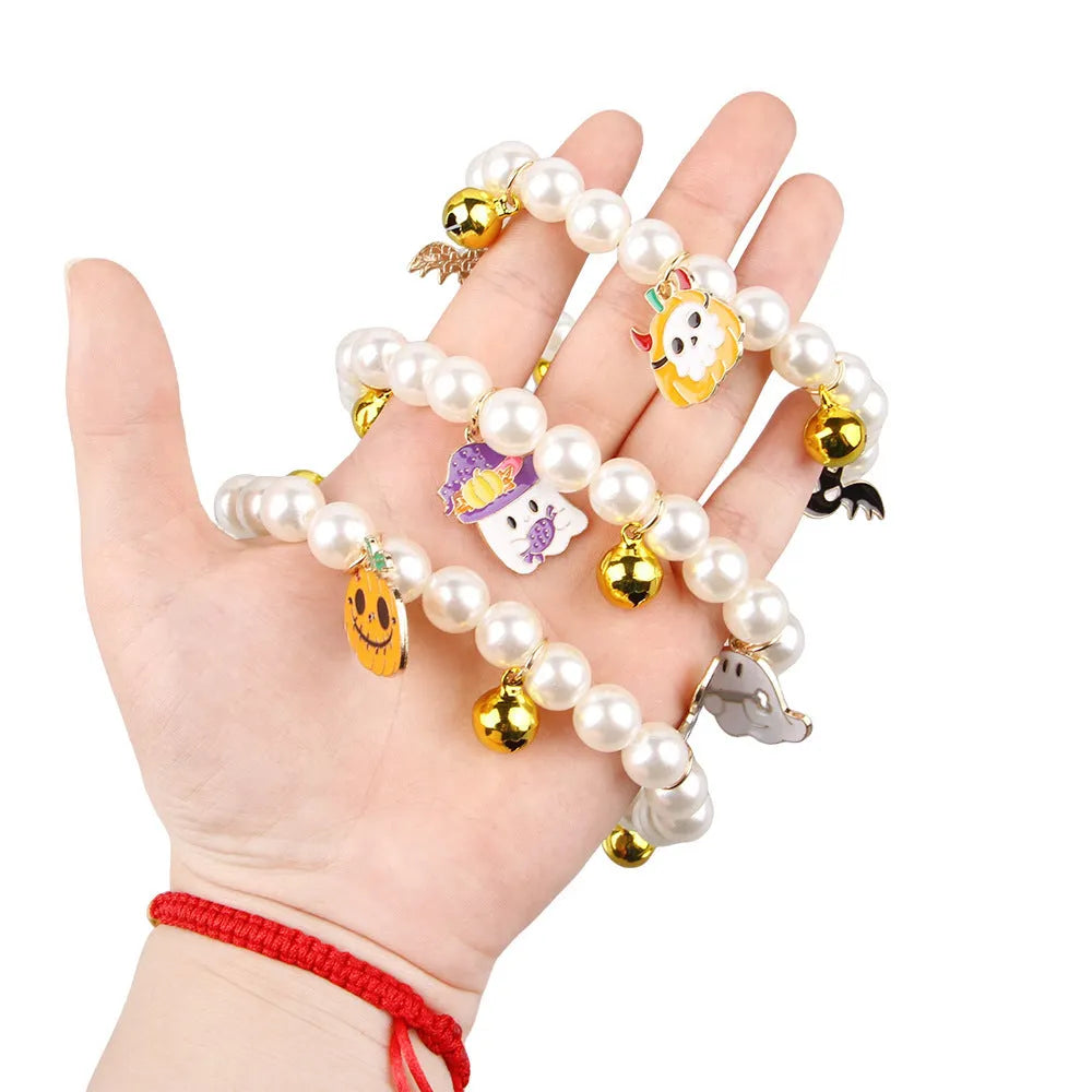 Three pearl and bell necklaces for pets laid out, suitable for cats and small dogs.