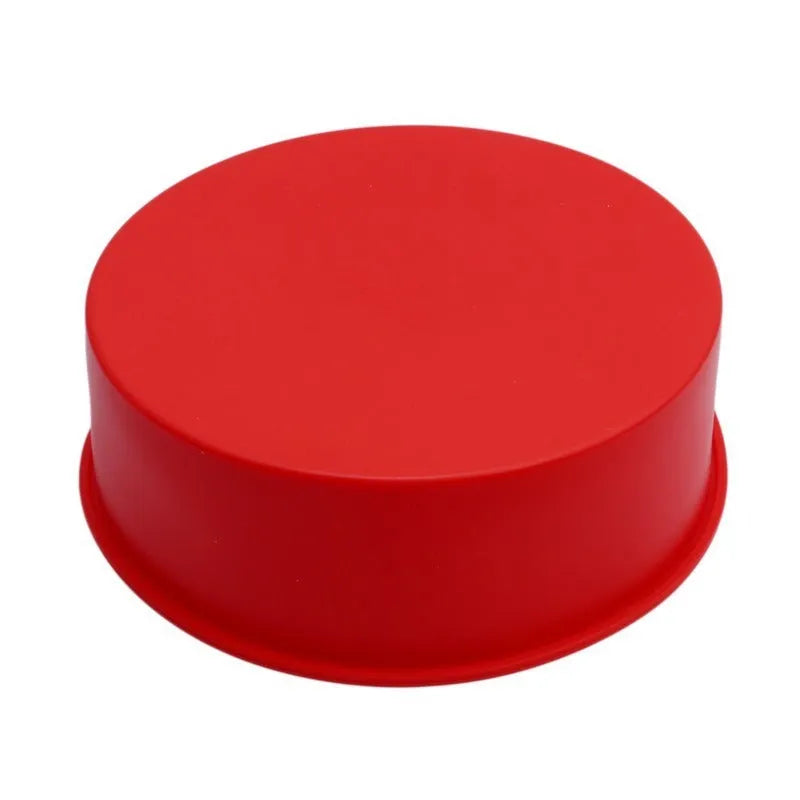 Set of three round red silicone cake moulds in 4-inch, 6-inch, and 8-inch sizes on a baking tray.