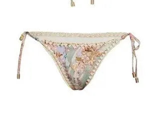 Women's creamy white floral bikini set with halter top, briefs, and a detachable ruffled skirt.