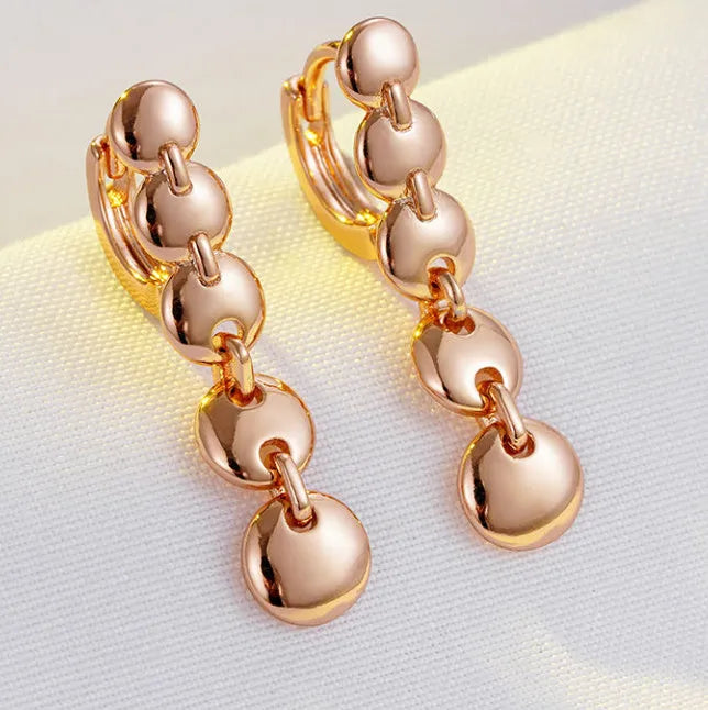 A pair of gold-coloured retro long round circle earrings with a woven copper texture.