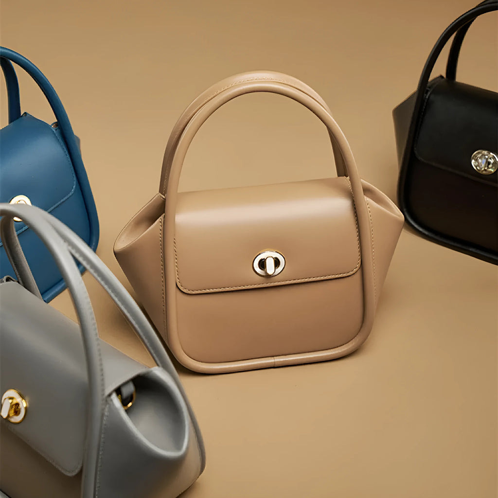 A women's cow leather wing-shaped handbag with a latch closure and a single shoulder strap.