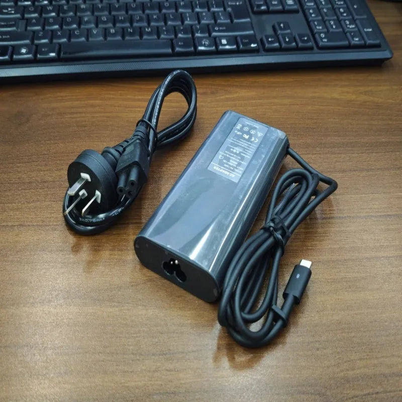 Black oval 65W Type-C laptop power adapter with multiple international plug configurations