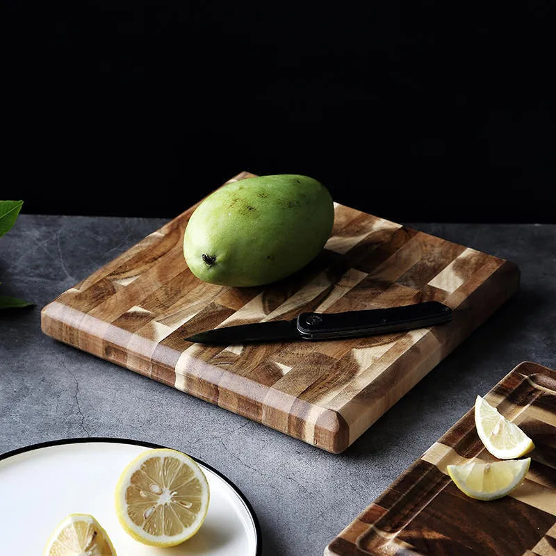 Brown solid wood chopping board with parquet pattern, shown on a kitchen countertop.