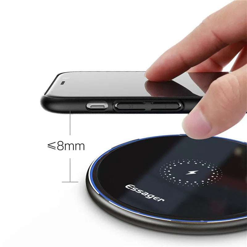 Black Qi fast wireless charging pad for smartphones on a desk