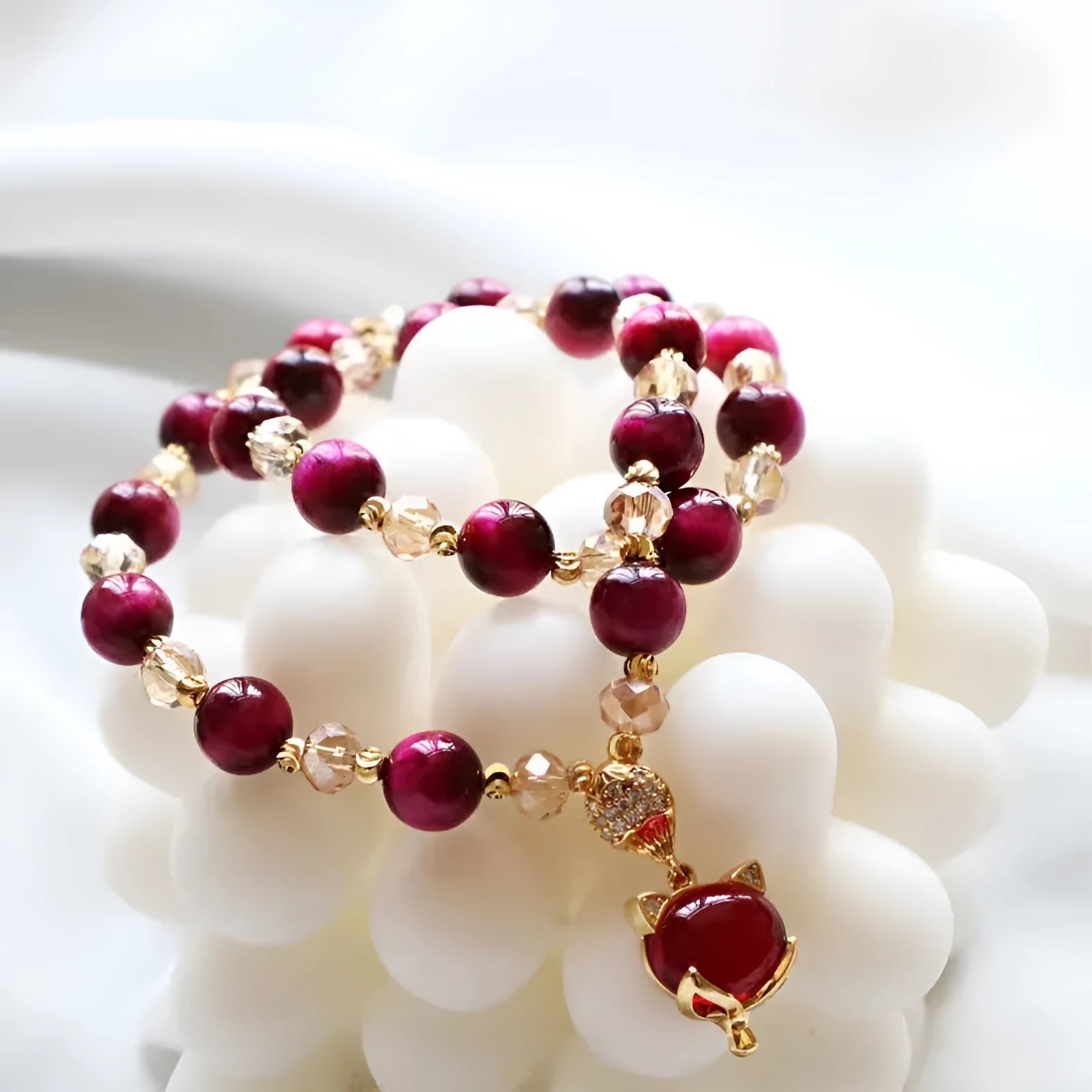 Handmade Tigereye stone bracelet with animal charm clasp on wrist, showing single and double chain styles in green and rose red.