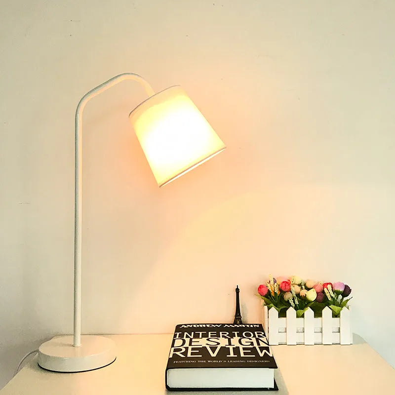 A modern LED table lamp with a push button dimmer switch on its base.
