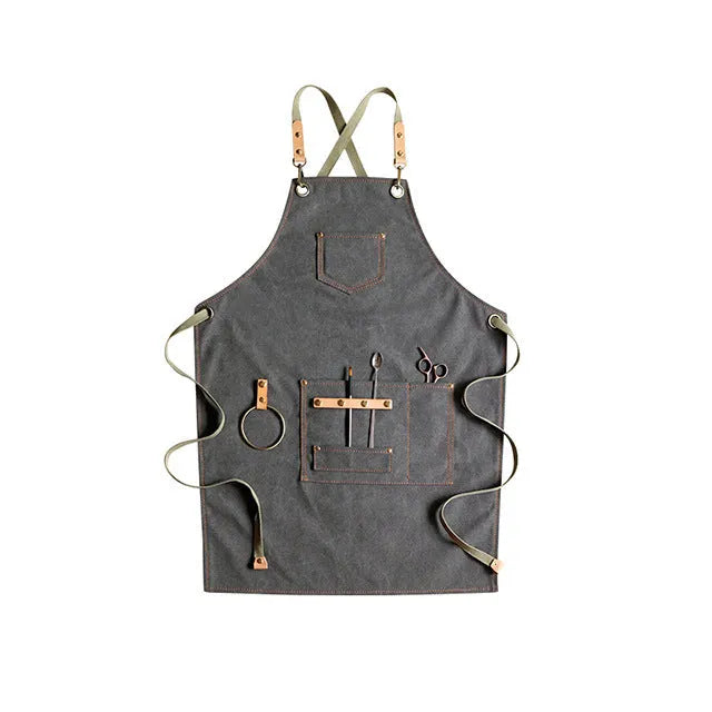 Canvas apron with cross-back straps in camel colour.