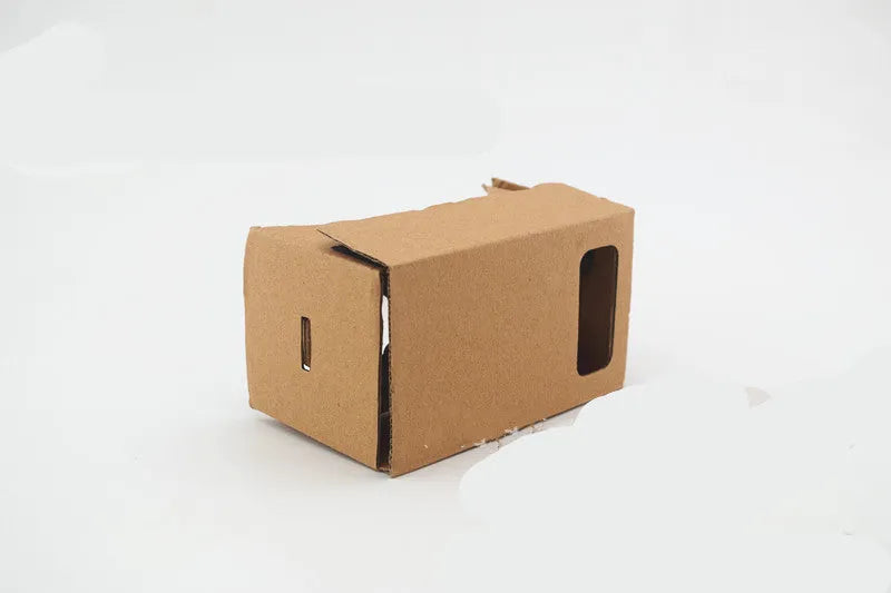 Pink and white VR Cardboard Glasses headset for 6-inch smartphones on a table.