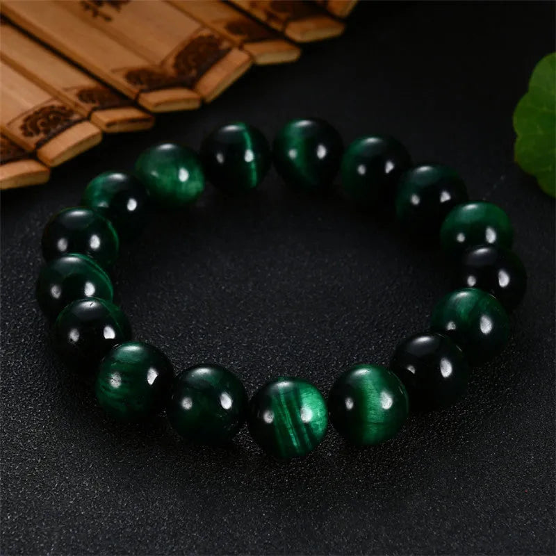 A natural green tiger eye stone bracelet with polished geometric beads on a wrist.